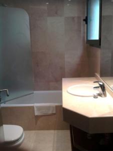 a bathroom with a sink and a toilet and a tub at Apartamento Llenaire in Pollença