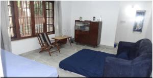 Una sala de estar con un sofá azul y una silla. en Anashwara, en Kozhikode