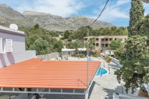 un tetto arancione su un edificio con montagne sullo sfondo di Ilias Studios Sevasti Kalymnos a Panormos Kalymnos