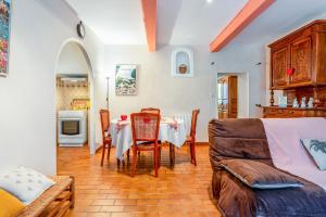 a kitchen and dining room with a table and chairs at Le Mas Des Glycines in Les Vignères