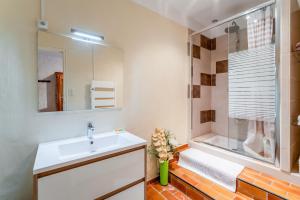 a white bathroom with a sink and a shower at Le Mas Des Glycines in Les Vignères +16 photos