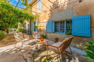 a group of chairs and a table in front of a building at Le Mas Des Glycines in Les Vignères