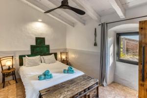 a bedroom with a bed with blue towels on it at Mas Tarres L'acacia Only Adults in Madremanya +25 photos