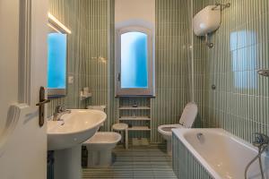 a bathroom with two sinks and a tub and a toilet at Villa Di Charme Ischia Porto in Ischia