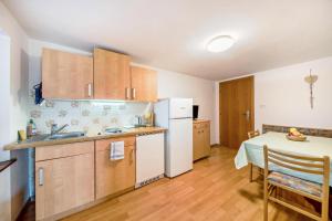 a kitchen with a table and a white refrigerator at Malgorerhof Sonja in San Genesio Atesino