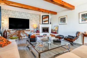 サリアンにあるVilla Plein Soleilの暖炉とテレビのあるリビングルーム