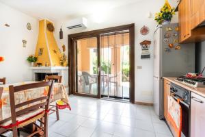 a kitchen with a table and a refrigerator at Villa Marta in Villasimius