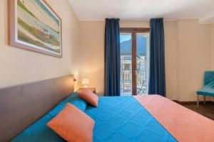 ポルレッツァにあるForesteria - bb Sul Lagoの青いベッドと窓のある寝室