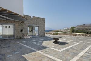 a stone patio with a bench in front of a building at Villa Coventina in Agios Ioannis Mykonos
