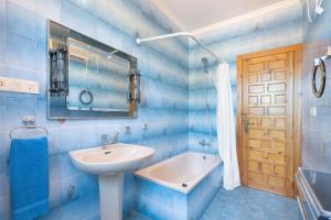 a blue tiled bathroom with a sink and a mirror at El Cachorro in Altura +37 photos