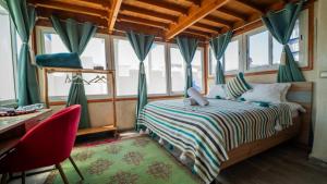 Un dormitorio con una cama, un escritorio y ventanas. en Stella 4 - studio deluxe, rooftop en médina, en Essaouira