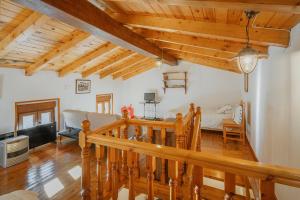 ein Wohnzimmer mit Holzdecken und einer Treppe in der Unterkunft La Casa De Sara in Llánaves de la Reina