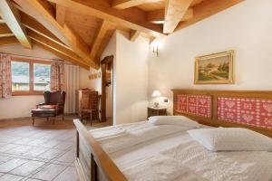 ein Schlafzimmer mit zwei Betten und einem Stuhl in der Unterkunft Au Petit Chevrot - Garden in Aosta