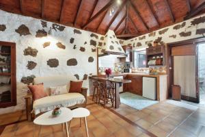 een keuken en woonkamer met een bank en een tafel bij Casa Aregume in Los Silos