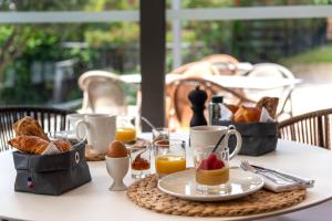 a table with a breakfast of croissants and orange juice at Zenitude Hotel La Valadière, Ascend Hotel Collection in Montpellier