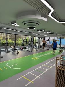 a gym with a green gym floor with people exercising at The One Condo - Family Suite 2BDR Pool View in Chiang Mai