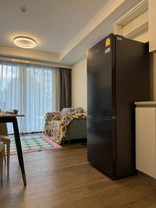 a kitchen with a black refrigerator in a room at The One Chiang Mai 214 - Family Suite 2BR 2bath, Pool View near Central Festival in Chiang Mai +83 photos