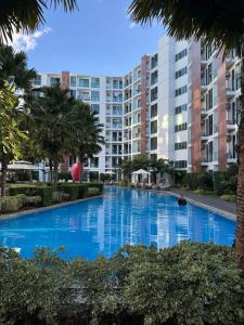 a large blue swimming pool with buildings in the background at The One Chiang Mai 214 - Family Suite 2BR 2bath, Pool View near Central Festival in Chiang Mai