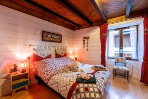 une chambre avec un ours en peluche assis sur un lit dans l'établissement Aux 4 saisons, à Le Bouchet-Mont Charvin