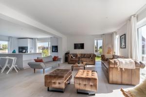 a living room with leather furniture and a kitchen at Les Palissades - La mer du bon côté in Saint-Pierre-Quiberon