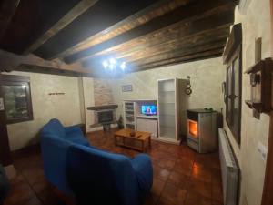 CelisにあるLos Avellanos Casa 1の青いソファとテレビのあるリビングルーム