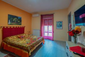 a bedroom with a bed with a red headboard and a window at Casa Monet 90 wifi-parking in Capodimonte