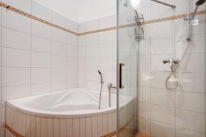 a bathroom with a tub and a shower at Traumschlößchen 100 m vom Strand in Heringsdorf +21 photos