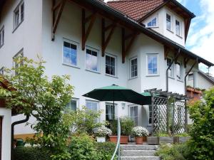 UnterkirnachにあるFerienwohnung am Wildpflanzenparkの傘を前に置いた白い家