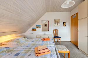 un dormitorio con una cama y una silla en Gästehaus Elke Jensen, en Langenhorn