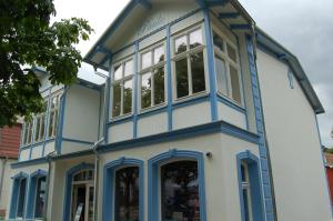 ein blau-weißes Haus mit Fenstern in der Unterkunft Villa Paula in Bansin