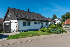 une maison blanche avec un toit noir dans l'établissement Fewo Georg, à Pfullendorf