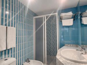 a bathroom with a shower and a sink and a toilet at Hotel Faranda Pathos Gijón, Ascend Hotel Collection in Gijón