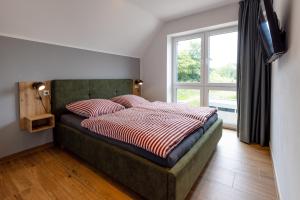 ダンガストにあるFerienhaus Strandnest Dangastの窓とテレビ付きのベッドのある寝室