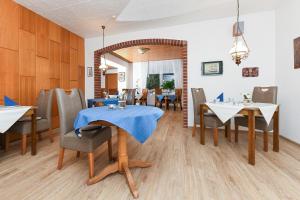 a dining room with a table and chairs at Hotel-Pension Marlies in Neuharlingersiel