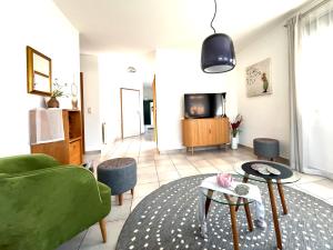 - un salon avec un canapé vert et une télévision dans l'établissement Lichte Wohnung zum Wohlfühlen, à Bastheim