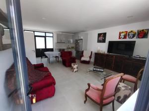 a living room with red furniture and a flat screen tv at Gite espumante in Mamarrosa