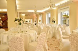 a room full of tables and chairs with white table cloths at Arti Minijos - Didžioji salė in Priekulė