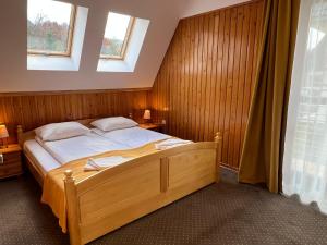 a bedroom with a large wooden bed with two windows at Willa Halka in Zakopane +228 photos