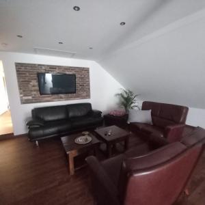 a living room with a couch and a tv on a wall at Hartmannshof in Hau