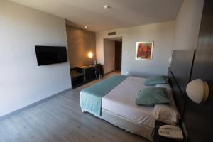 a hotel room with a bed and a television at Hotel Ciudad de Ponferrada, Ascend Hotel Collection in Ponferrada