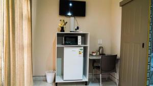 a microwave on top of a refrigerator in a room at 3rd on Belgrave Guesthouse in Kimberley