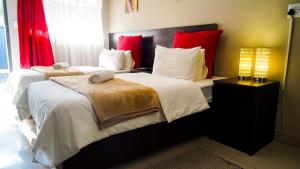 a bedroom with two beds with white and red pillows at 3rd on Belgrave Guesthousae in Kimberley