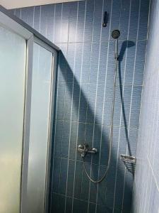 a shower with a hose in a blue tiled bathroom at RatanakCity hotel in Banlung +84 photos