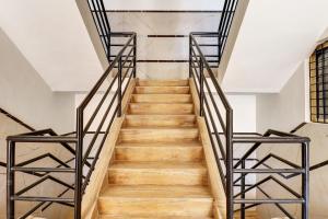 a staircase with metal railings and wooden floors at Super Hotel O Indian Residency, Near Adams Academy, Kadugodi in Bengaluru +22 photos