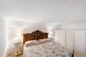 1 dormitorio con 1 cama, 2 mesitas de noche y 2 lámparas en La casa di Iris con posto auto, en Diano Marina