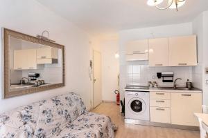 Una sala de estar con un sofá y una cocina. en La casa di Iris con posto auto, en Diano Marina 14 fotos más