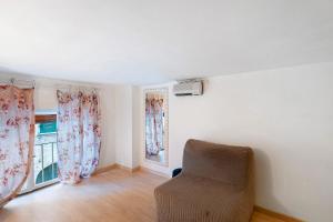 Una sala de estar con una silla y una ventana. en La casa di Iris con posto auto, en Diano Marina