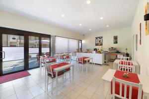 ポルレッツァにあるForesteria - bb Sul Lagoの赤と白のテーブルと椅子が備わるレストラン