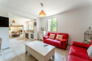 ソルマーヌ・ド・ボークリューズにあるBergeries Saumane, Grande Bergerieの赤いソファとテーブルのあるリビングルーム