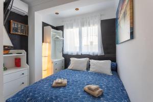 a bedroom with a blue bed with two pairs of slippers at Seaview Apartment N12 in El Perelló